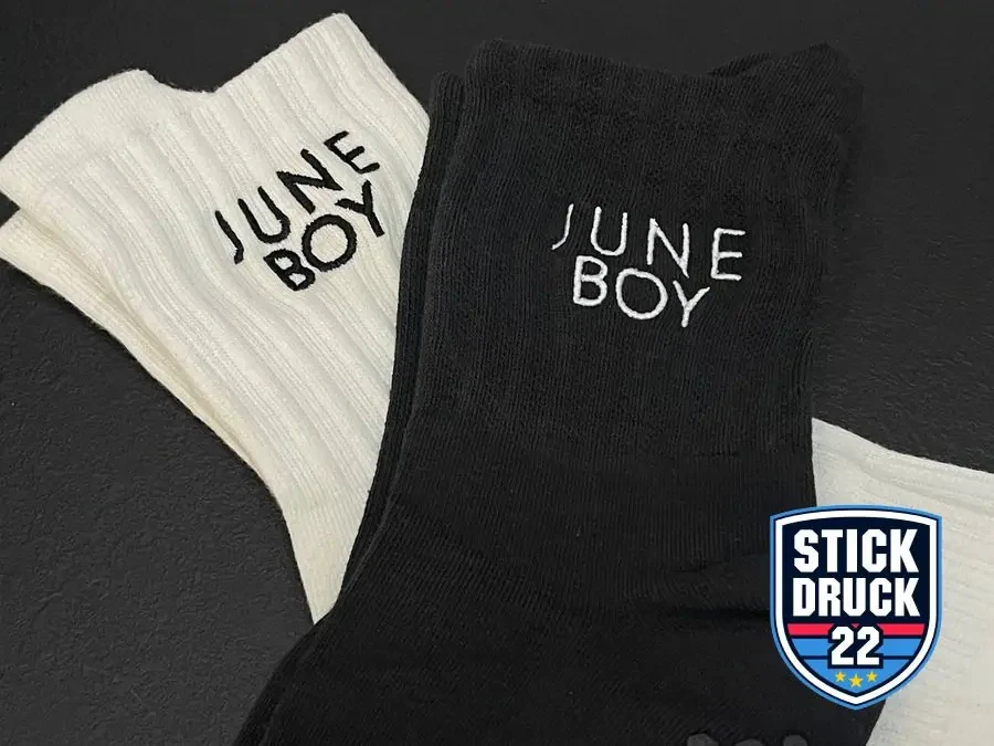Schwarze und weiße Socken mit gesticktem Schriftzug aus der STICKDRUCK22 Produktion