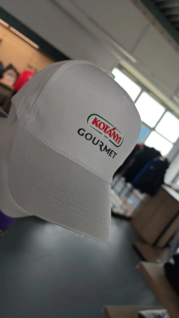 Weiße STICK22 Projektcap mit gedrucktem Kotányi Gourmet Logo auf der Front