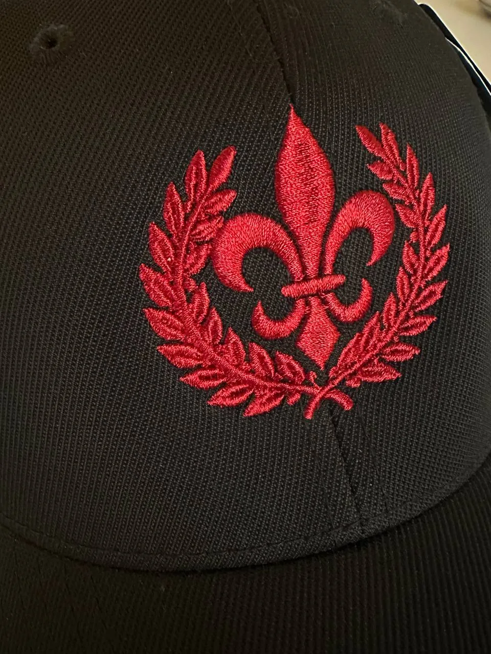 Schwarze Cap mit rot gesticktem Wappen und Lorbeerkranz, Kappen-Stickerei Wien