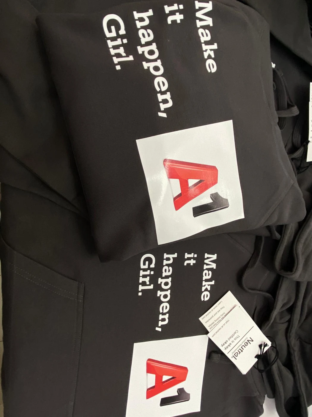 Schwarze Textilien mit rotem Logo und weißem Schriftzug bedruckt