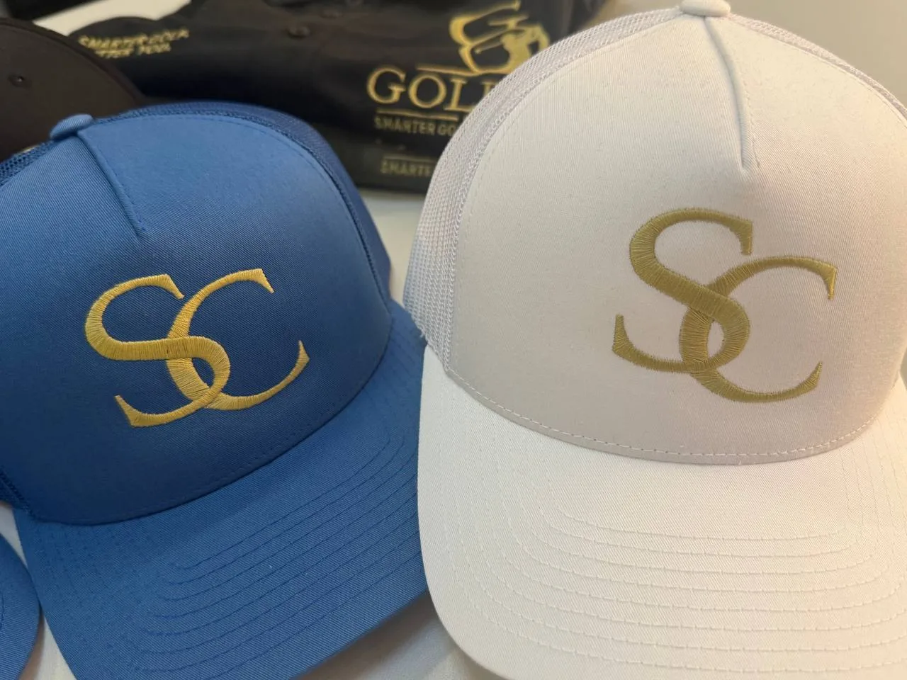 Blaue und weiße Trucker Caps mit goldenem Monogramm gestickt, Kappen-Stickerei Wien