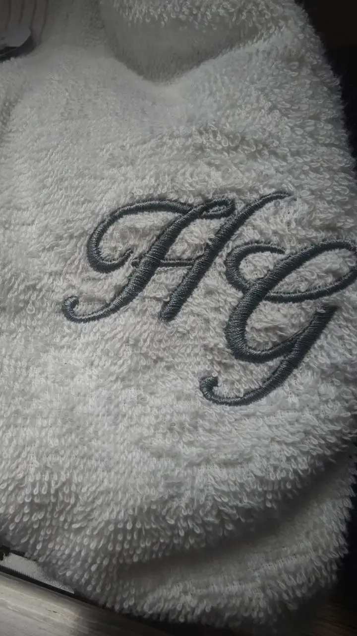 Monogramm HG in Grau auf weißem Frottee gestickt, Monogrammstickerei Wien