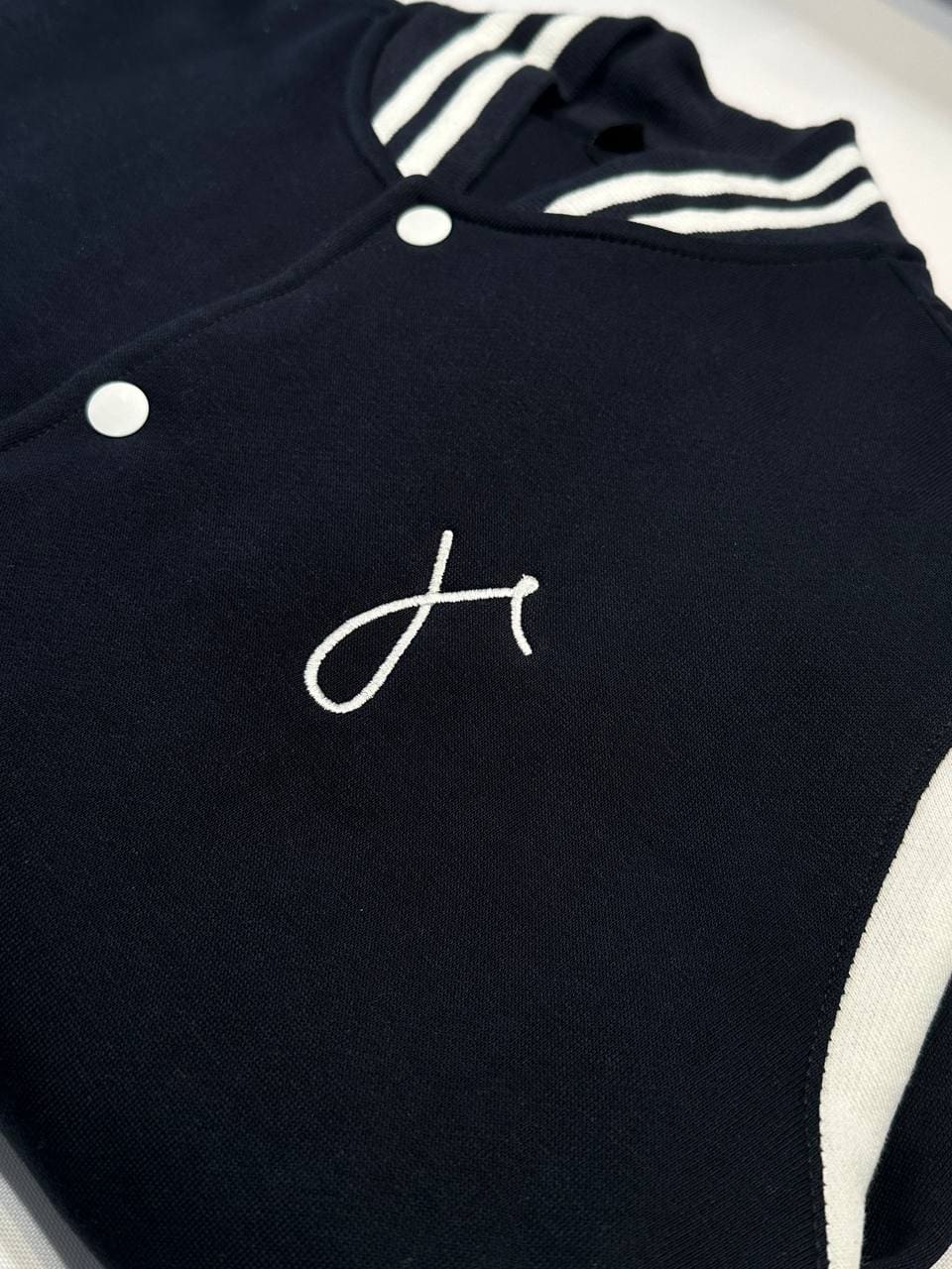 Initiale H gestickt auf schwarzer Varsity Jacke, Monogramm Stickerei auf College Jacke Wien