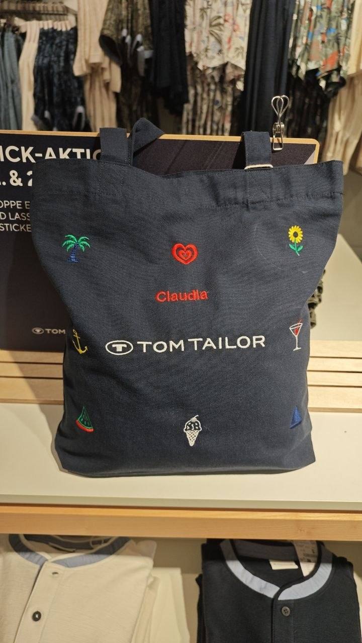Baumwolltasche mit Live-Personalisierung Claudia und bunten Icons wie Palme Herz Sonnenblume, Tom Tailor Stick-Aktion im Store