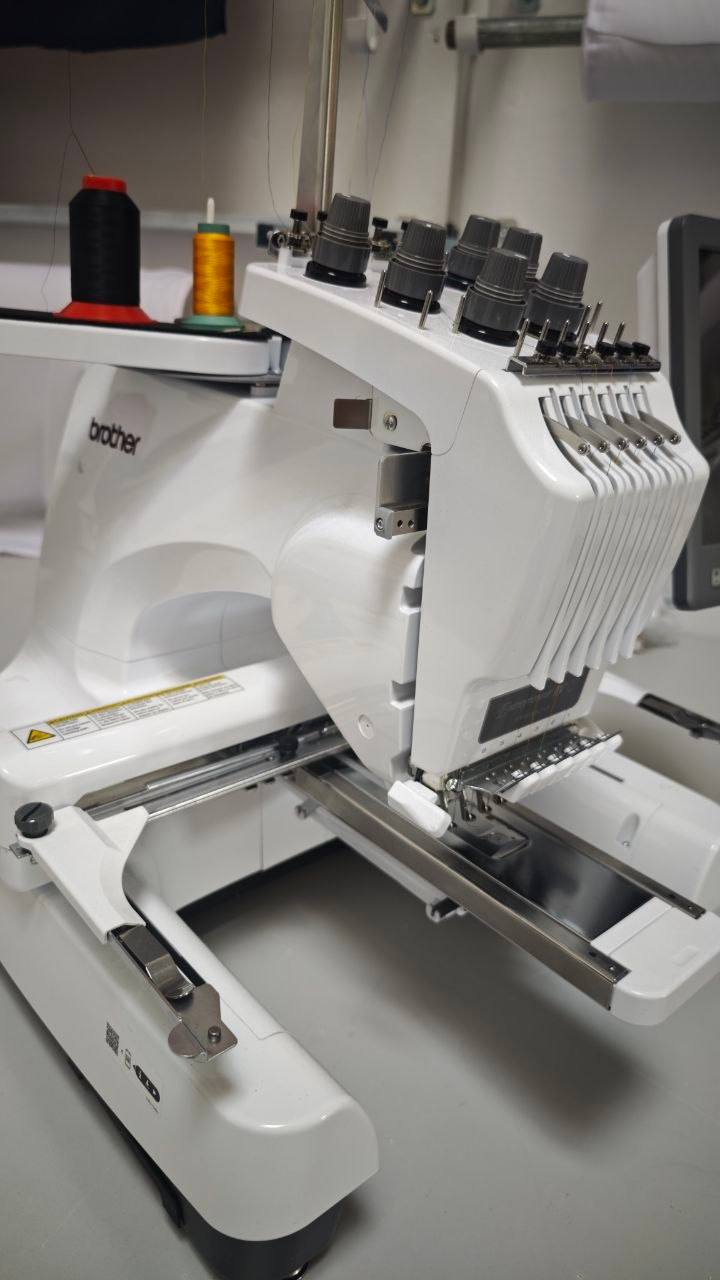 Brother Entrepreneur W Stickmaschine im Profil mit roten und goldenen Garnrollen