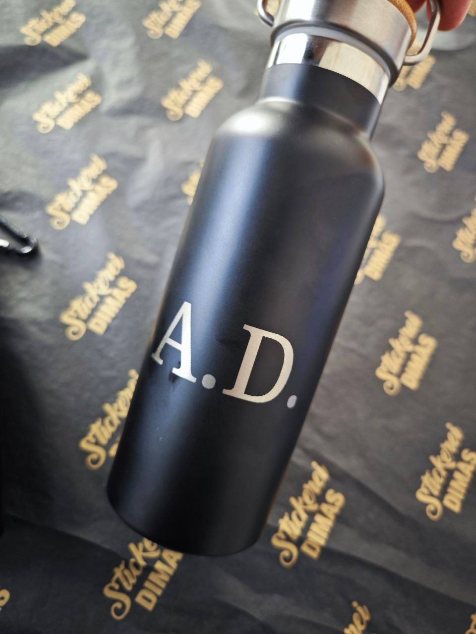 Detailansicht Lasergravur Monogramm A.D. auf schwarzer Edelstahlflasche