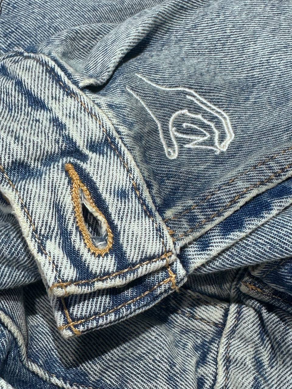 Feines helles Monogramm auf heller Jeansjacke gestickt, Detailaufnahme