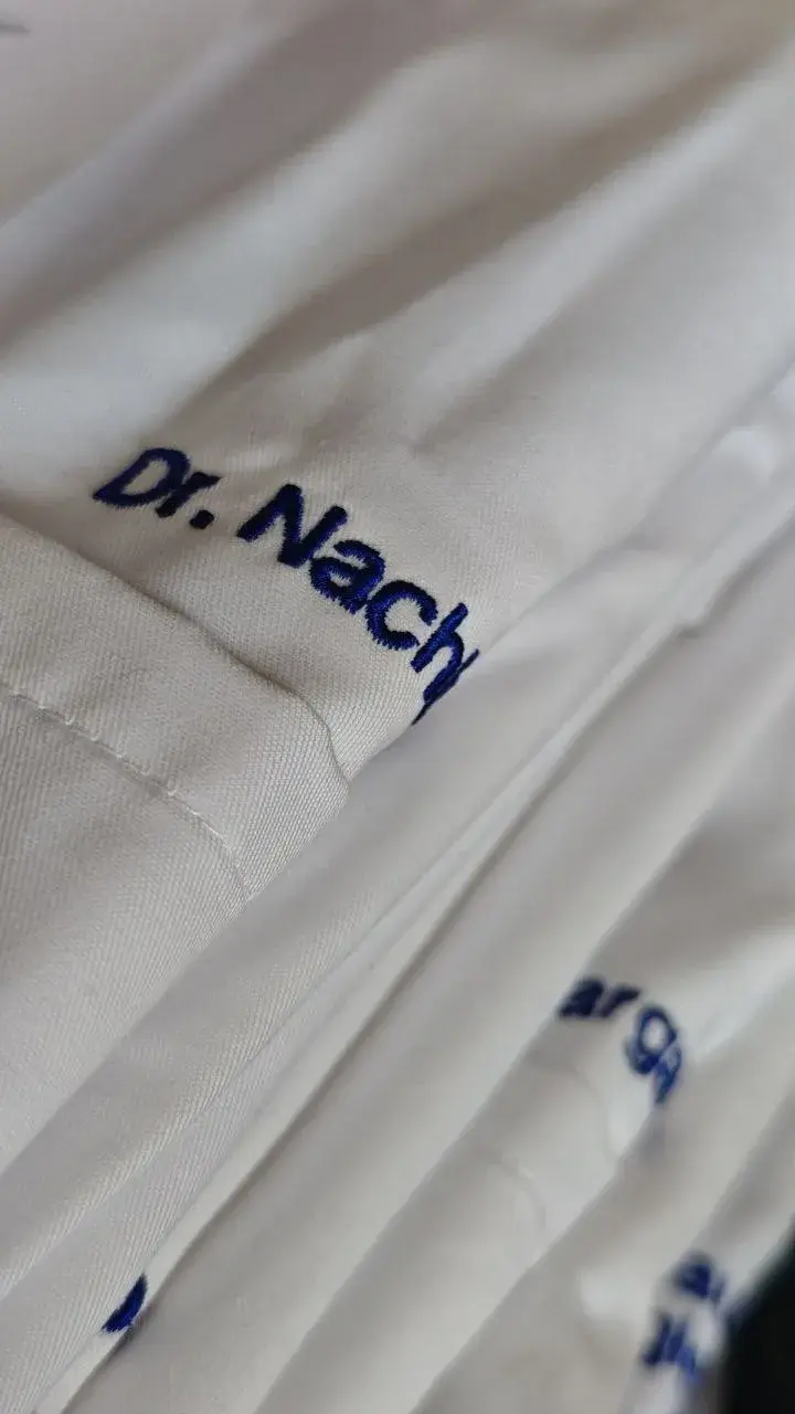 Namensstickerei auf weißer Arbeitskleidung