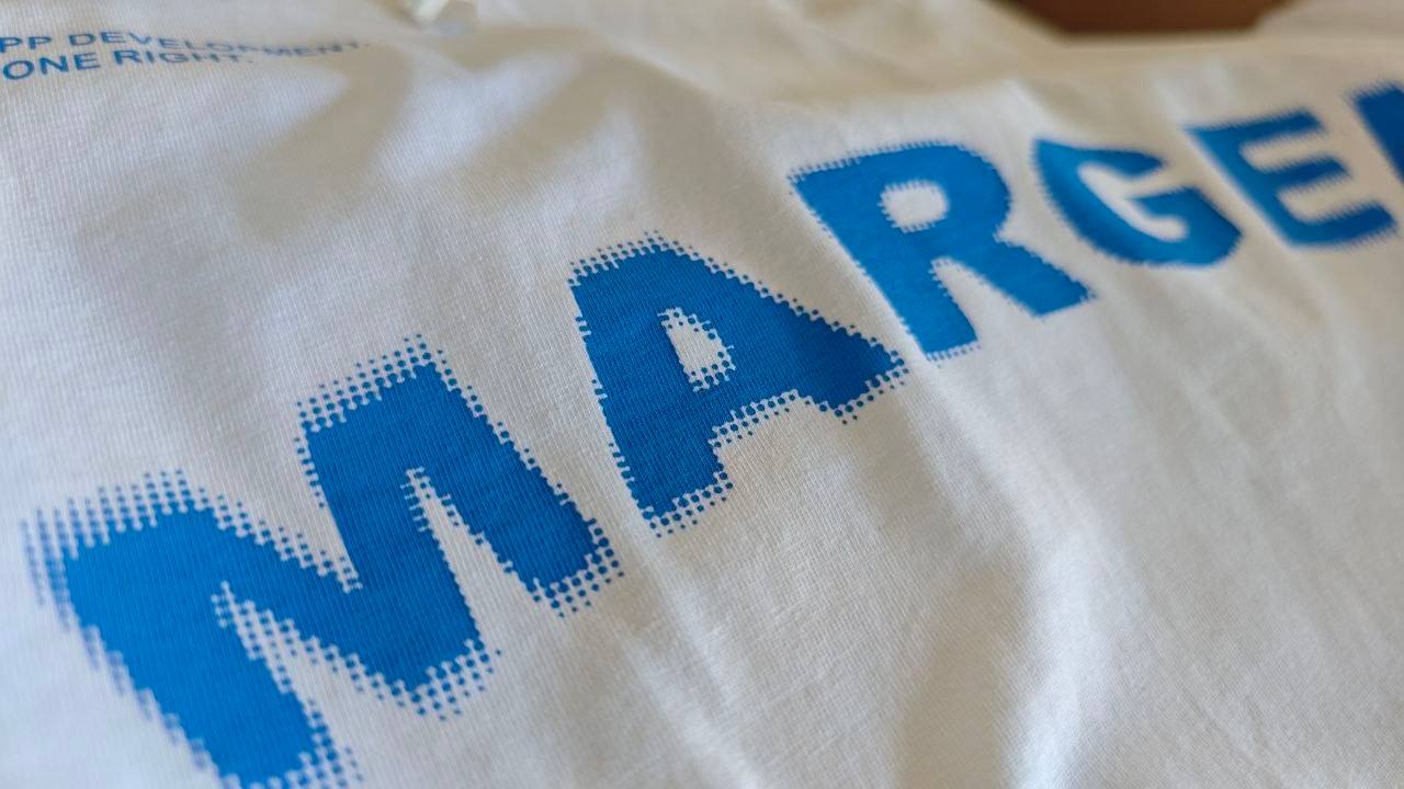 Weißes T-Shirt mit großflächigem blauem Schriftzug in Pixeloptik