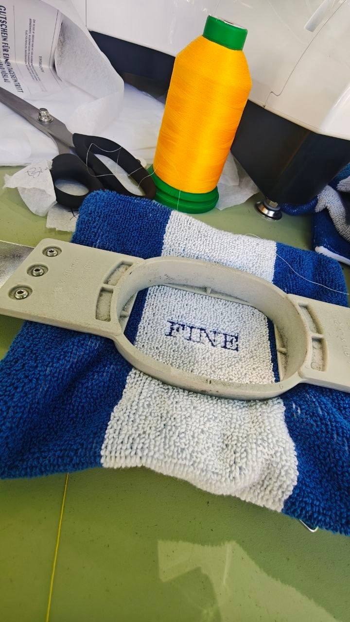 Sticken von kleinen Bags und Handtüchern, Nahaufnahme Stickrahmen mit Schriftzug FINE