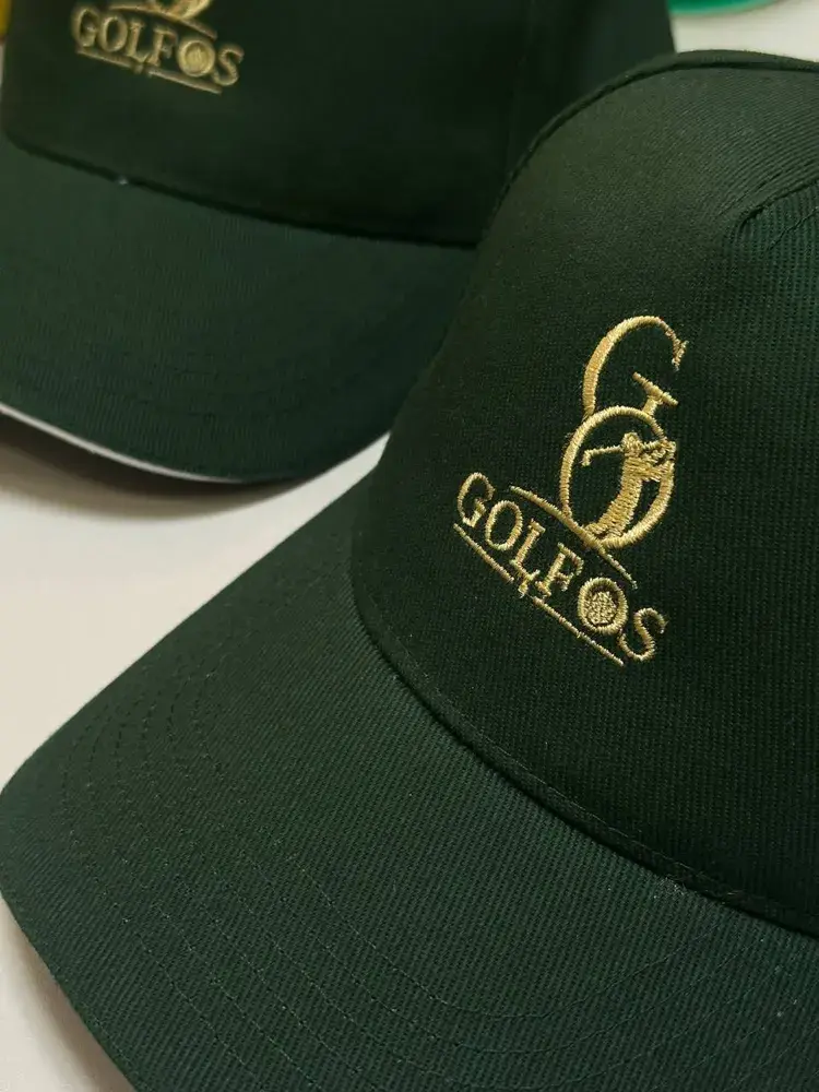 Grüne Kappen mit goldfarben gesticktem Logo