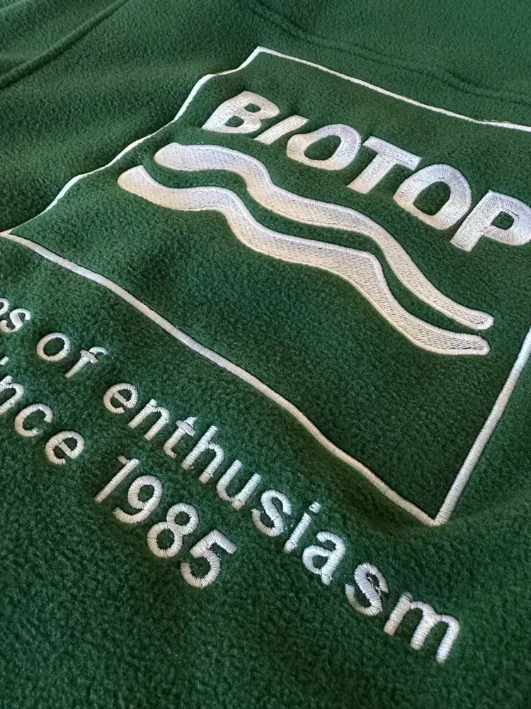 Grüne Fleecejacke mit gesticktem Firmenlogo und Schriftzug aus der Produktion in Wien