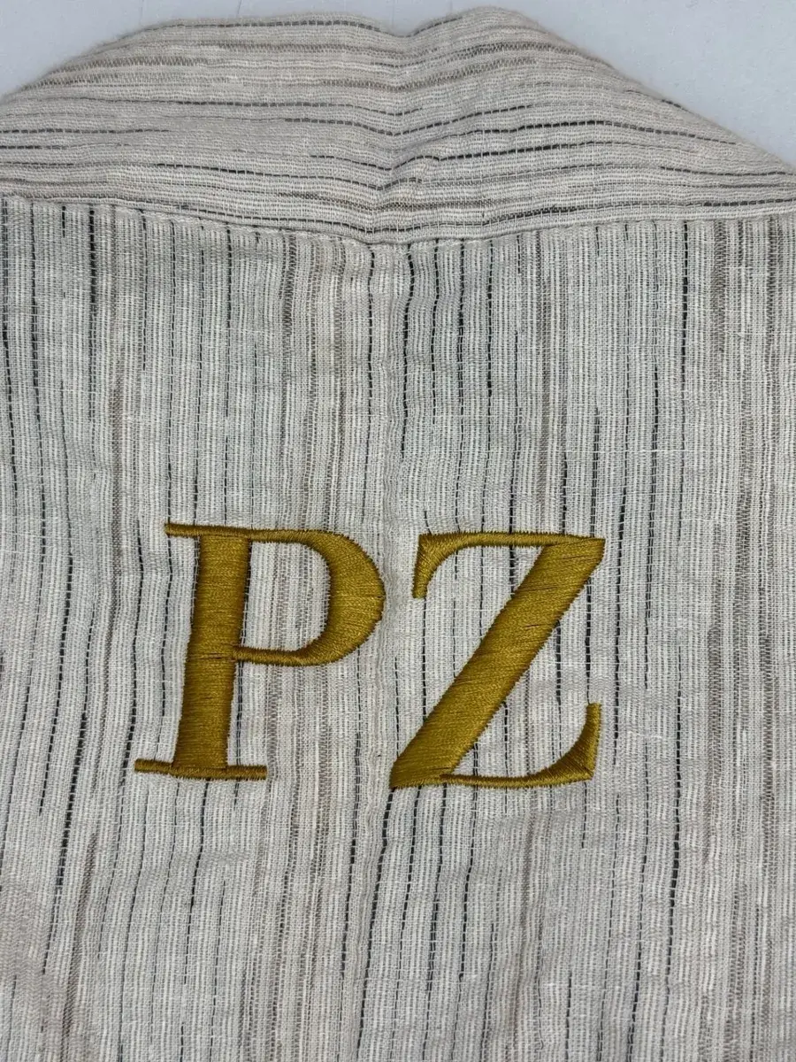 Goldenes Monogramm auf Hemd gestickt
