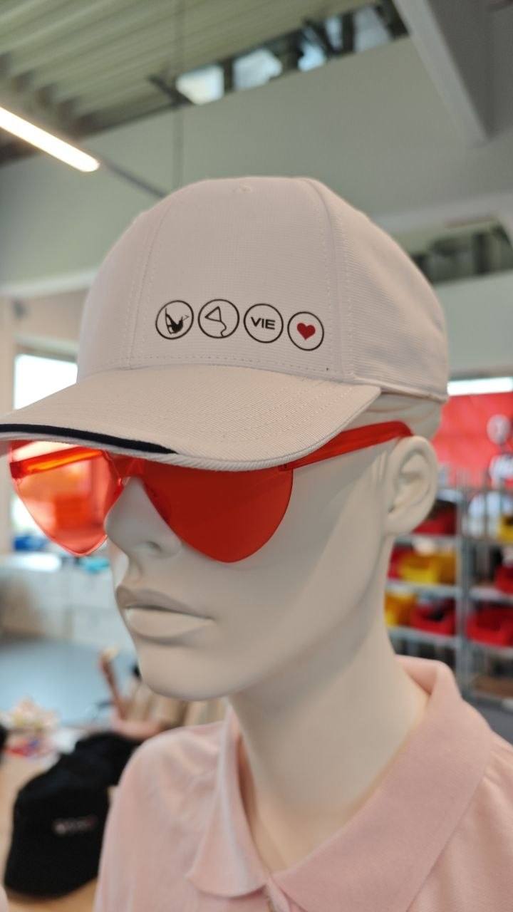 Weiße Kappe mit vier kleinen Logo-Buttons bedruckt, Markenkollektion Stick22 Wien