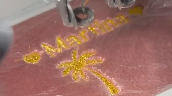 Stickmaschine Detailaufnahme, Nadel stickt Logo auf Textil Wien